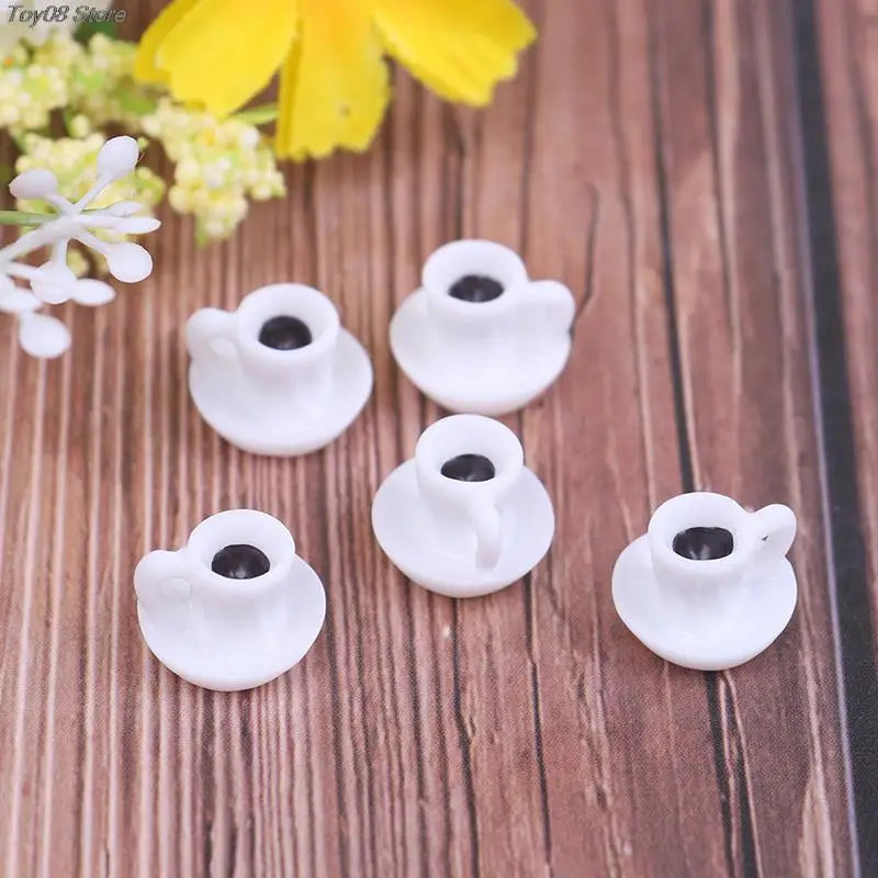 A set of five small white resin coffee cups for dollhouse kitchens displayed on a wooden surface.