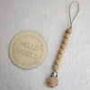 A wooden bead pacifier clip with a silicone teether on a leather cord.
