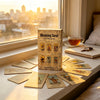 A wooden box of a Meaning Tarot deck with several spread cards laid out on a windowsill during sunrise.