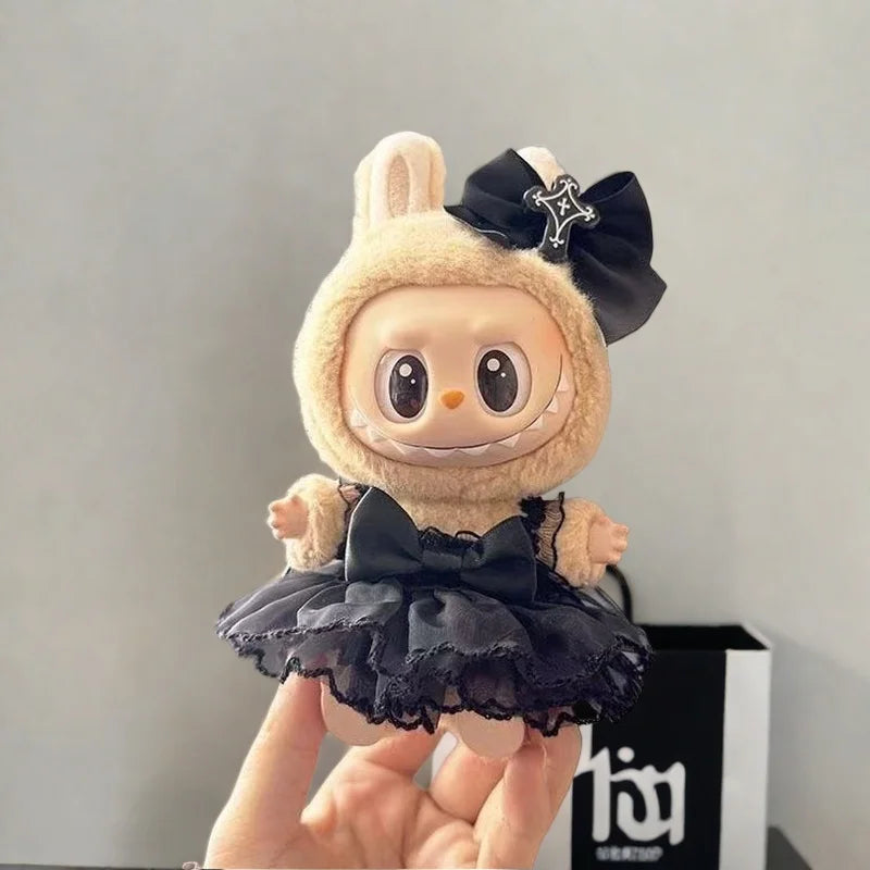 A cute plush doll dressed in a black bow and tulle skirt, resembling a leopard print sling dress.
