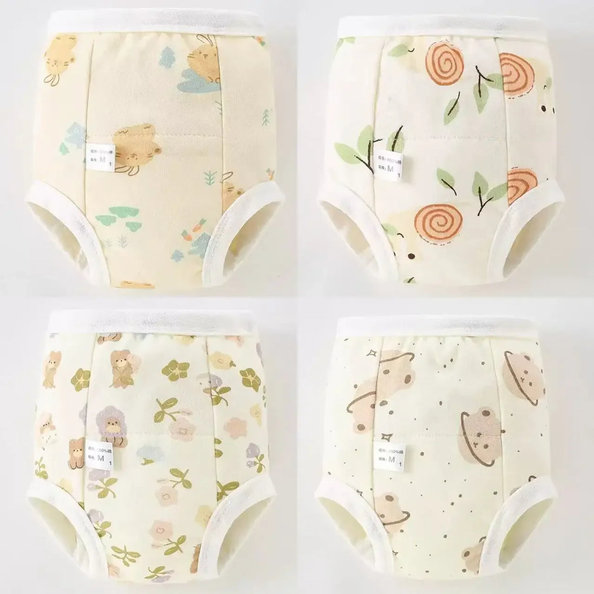 A set of four reusable cotton potty training pants for toddlers in light yellow with a subtle floral pattern.