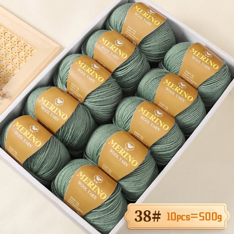 A box of Merino wool yarn in various shades of green and beige, packaged for knitting projects.