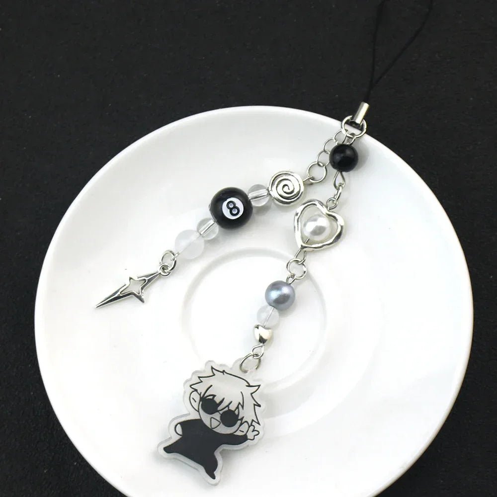 Anime-inspired keychain featuring a black silhouette charm and various bead charms on a white plate.