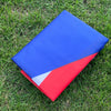 A folded Puerto Rico national flag banner showing the blue and red stripes on green grass.