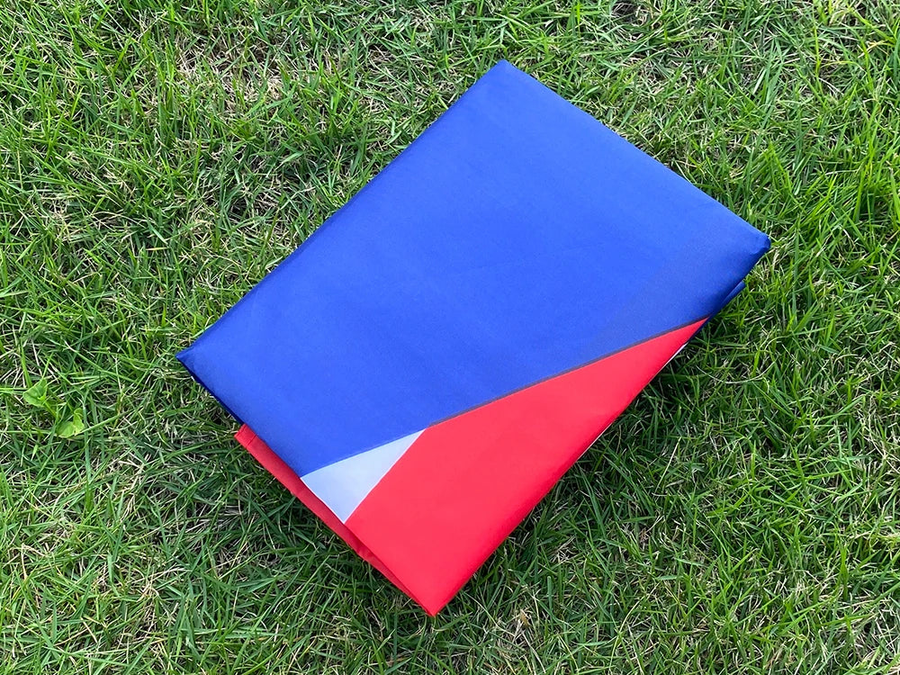 A folded Puerto Rico national flag banner showing the blue and red stripes on green grass.