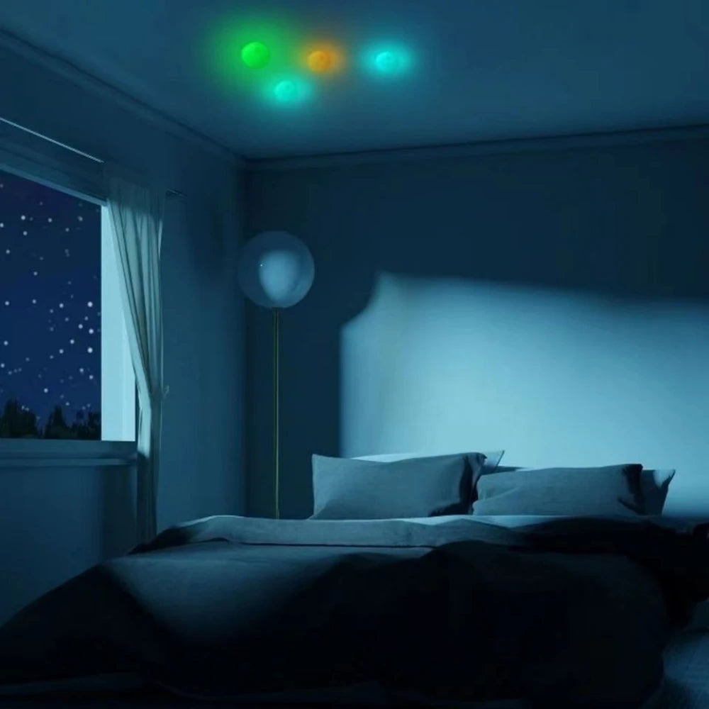 A dark bedroom scene with a window and a bed, illuminated by glowing green, orange, and blue lights above.