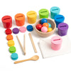 A set of colorful wooden cups and rainbow balls for a Montessori sorting game
