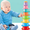 A baby is interacting with a colorful stacking cups toy set featuring floating boats.