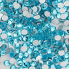 A close-up of assorted blue and clear glass crystal flatback rhinestones for nail art and crafts.
