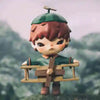 A small mischievous figure with reddish-brown hair and a green cap stands on a wooden platform.