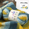 A ball of multi-colored gradient acrylic yarn is shown on a knitted fabric, with a label indicating 3 pieces equal to 300g.