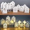 A collection of white and gold silicone molds shaped like houses, featuring hearts, trees, and festive designs.