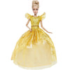 A blonde doll wearing a yellow sequined evening gown with sheer fabric and ruffled shoulders.