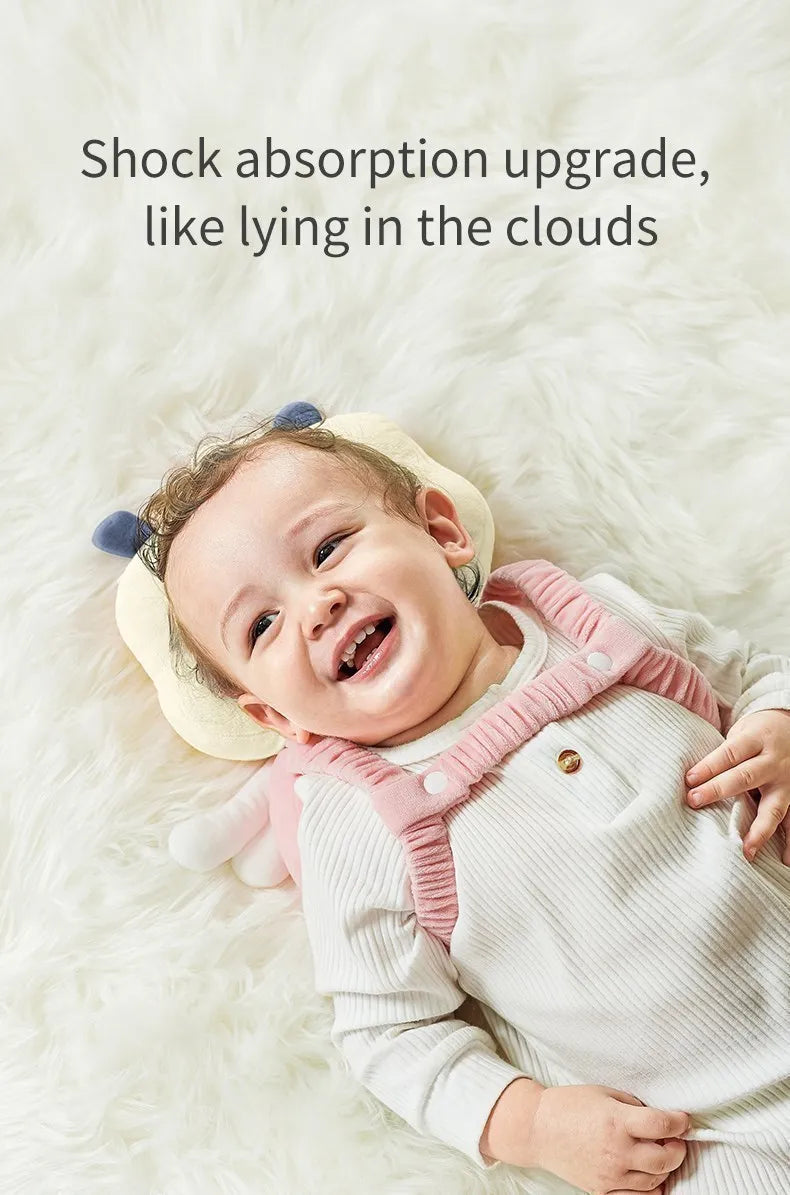 A smiling baby wearing a soft silicone head protection pillow while lying on fluffy white fur.