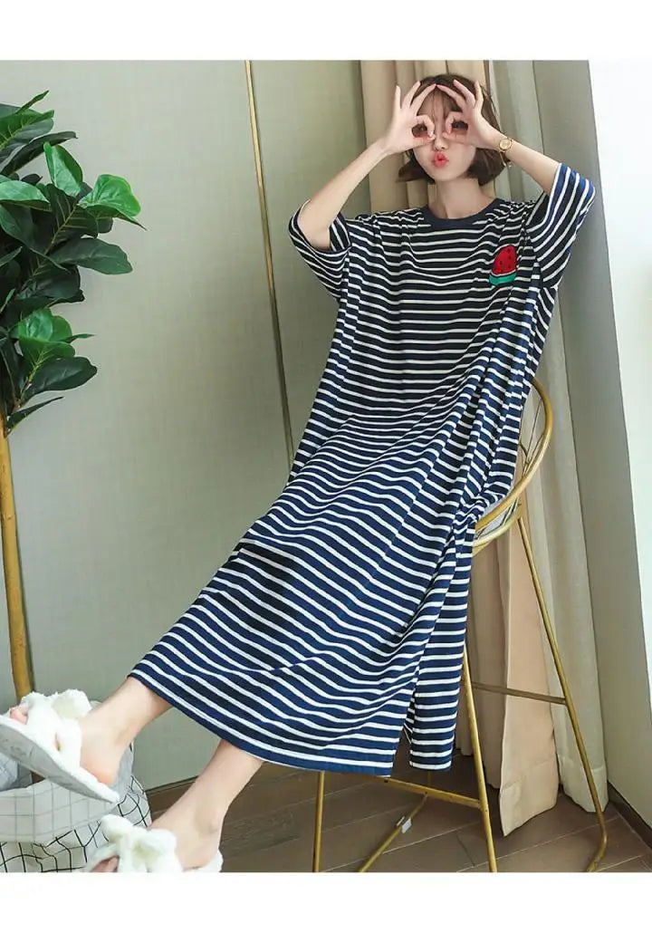 A woman models a navy and white striped short-sleeve lounge dress indoors.