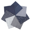 A collection of seven dark blue and white patterned cotton fabric squares for quilting and patchwork