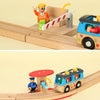 A wooden train track accessory set featuring a yellow figure and a blue train car on a light wood track.
