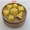 A set of yellow cheese dice cubes with numbers inside, displayed in a brown carrying case.