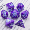 A set of purple resin dice featuring a black kitten design and numbered faces.