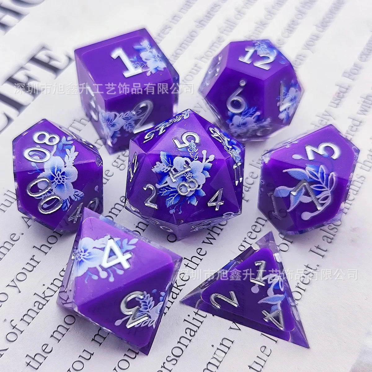 A set of purple resin dice featuring a black kitten design and numbered faces.