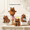 A set of wooden building blocks shaped like cute bears and a pink pig, displayed on a white mantelpiece.