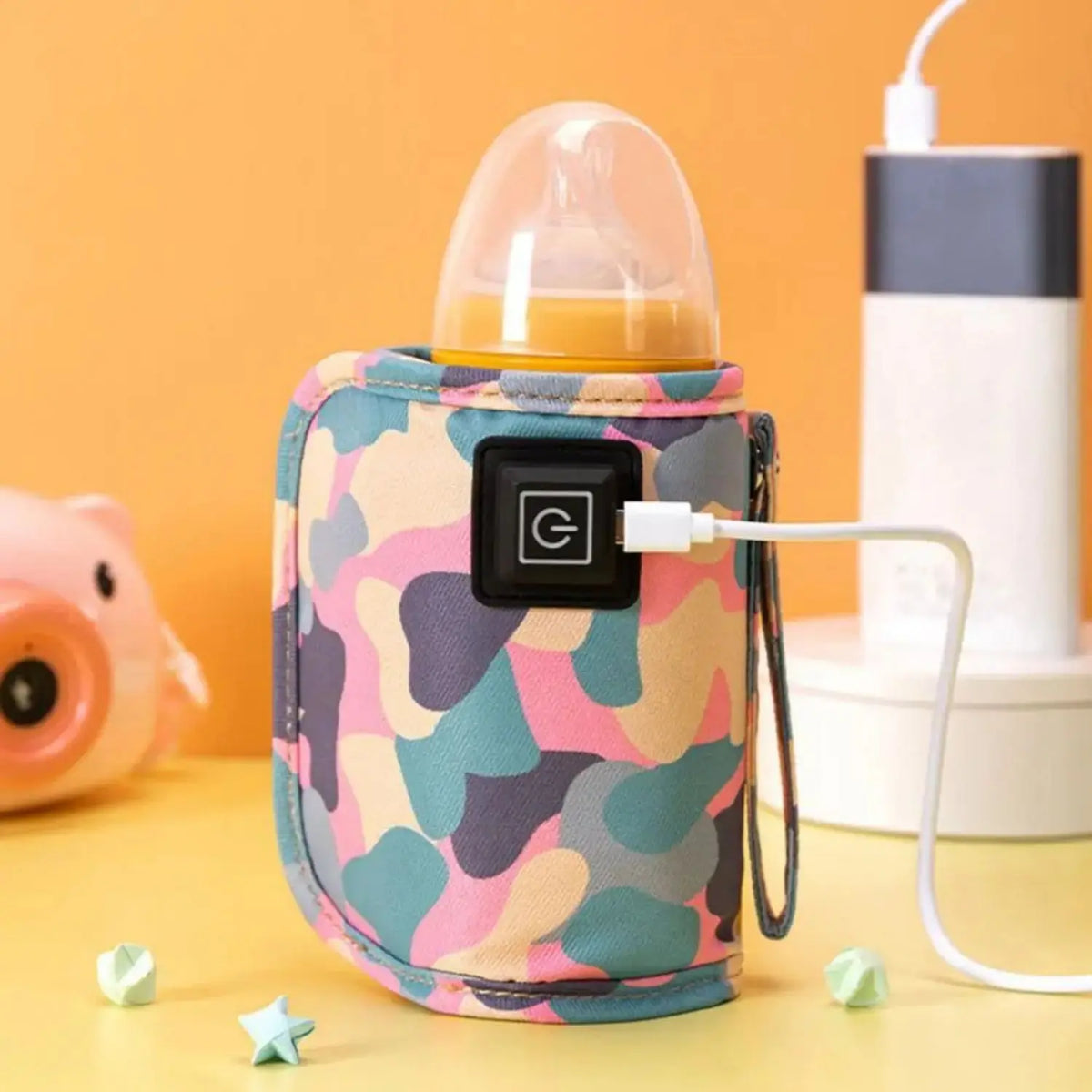 A pink and green camouflage insulated bag shaped like a baby bottle warmer with a white cord.
