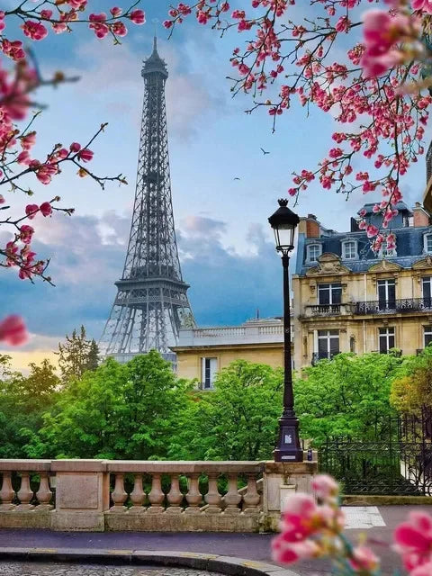 A painting of the Eiffel Tower framed by pink blossoms and green foliage.
