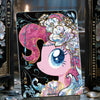 A collectible card featuring a pink pony with purple and white floral accents against a dark background.