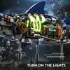 A mechanical shark building block set model with glowing lights is shown against a dark, watery background.