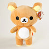A fluffy brown Rilakkuma strawberry bear plush toy with white accents and an attached tag.