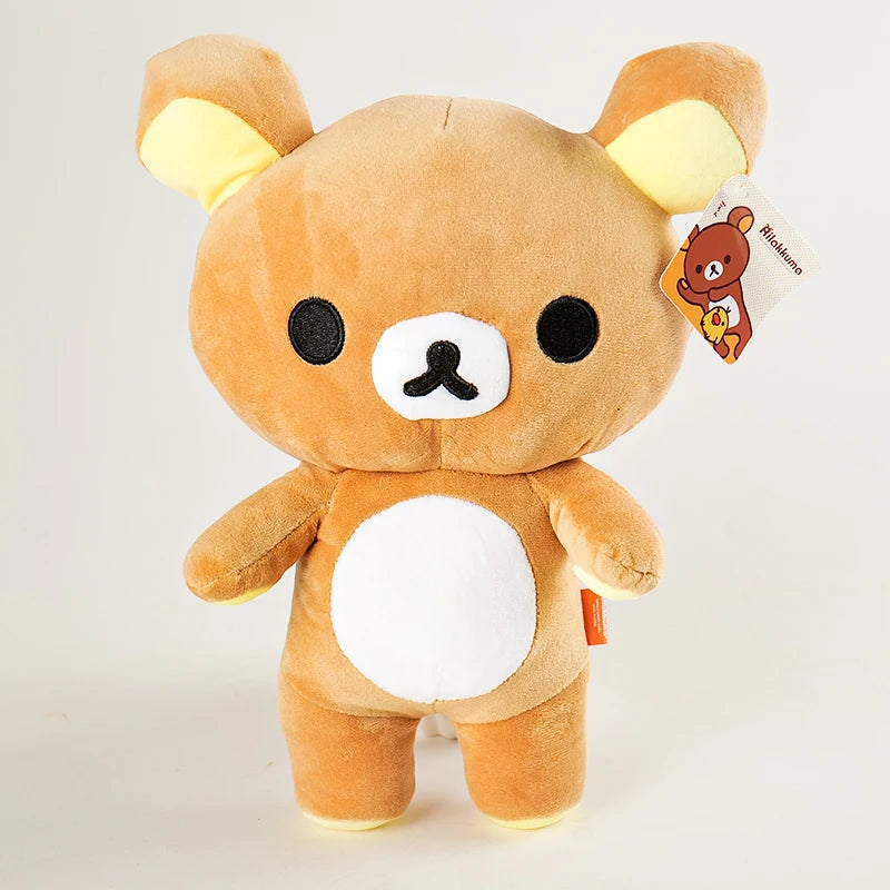 A fluffy brown Rilakkuma strawberry bear plush toy with white accents and an attached tag.