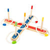 A wooden ring toss game with colored wooden pegs and rings set up on a cross-shaped board.