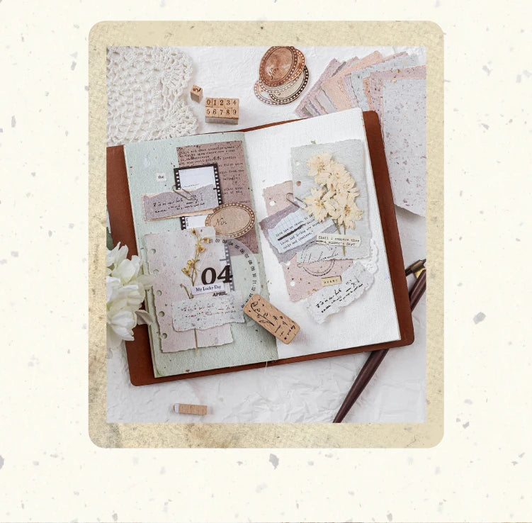 A vintage scrapbook paper combo kit featuring various aged papers, dried flowers, and decorative elements on a brown backgrou