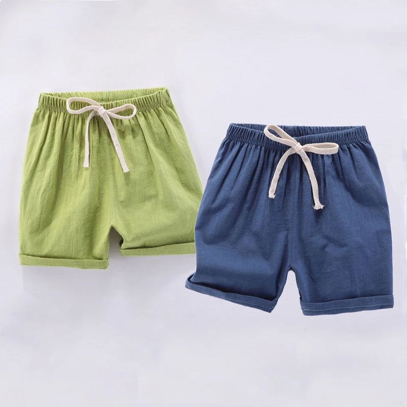 A pair of light green linen shorts with a drawstring waist and a pair of dark blue linen shorts with a drawstring waist.
