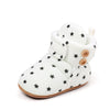 White baby winter snow boots with black star accents and fuzzy ball details