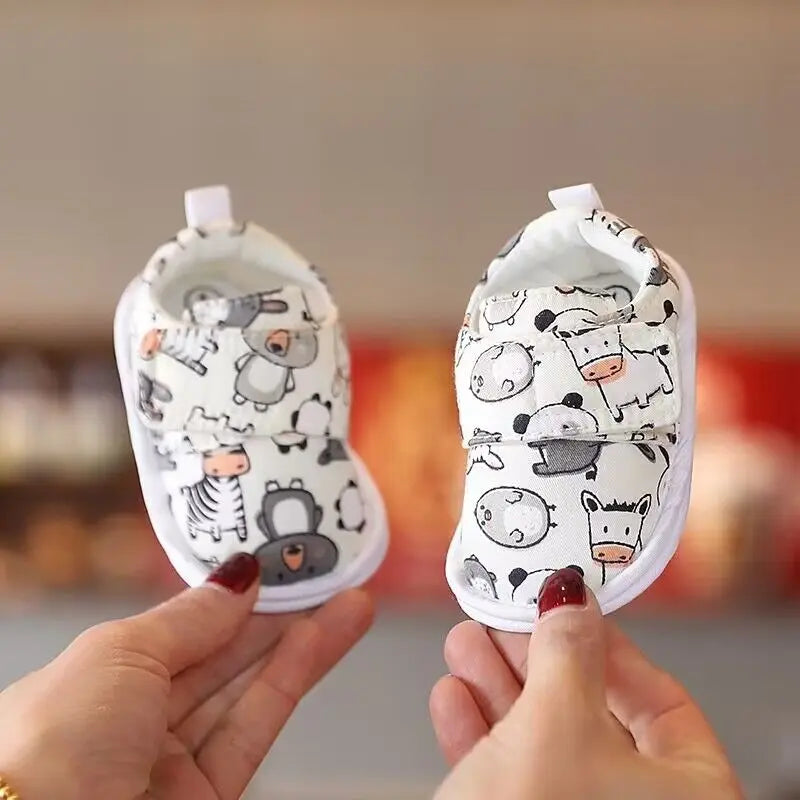 A pair of adorable bear soft sole first walker shoes for babies with a white background and cute animal patterns.