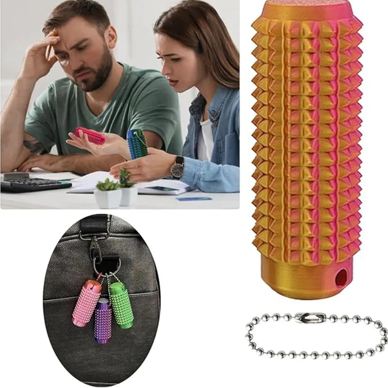A spiky sensory keychain in pink and green colors is shown next to a silver chain.