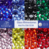 A collection of various colored glass rhinestones including blue, purple, black, and green stones.