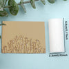 A light beige clay texture roller and a white candle are displayed on a light blue background with green foliage.