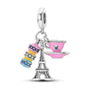 A silver heart charm bead with a pink zircon and a Eiffel Tower pendant.