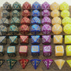 A collection of dragon-inspired polyhedral dice in various colors and shapes for tabletop role-playing games