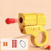 A yellow mini shell-ejecting fidget pistol with a red pellet and related components shown on a light background.