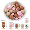 A bowl filled with various silicone beads shaped like cartoon animals in shades of pink and brown for DIY jewelry making