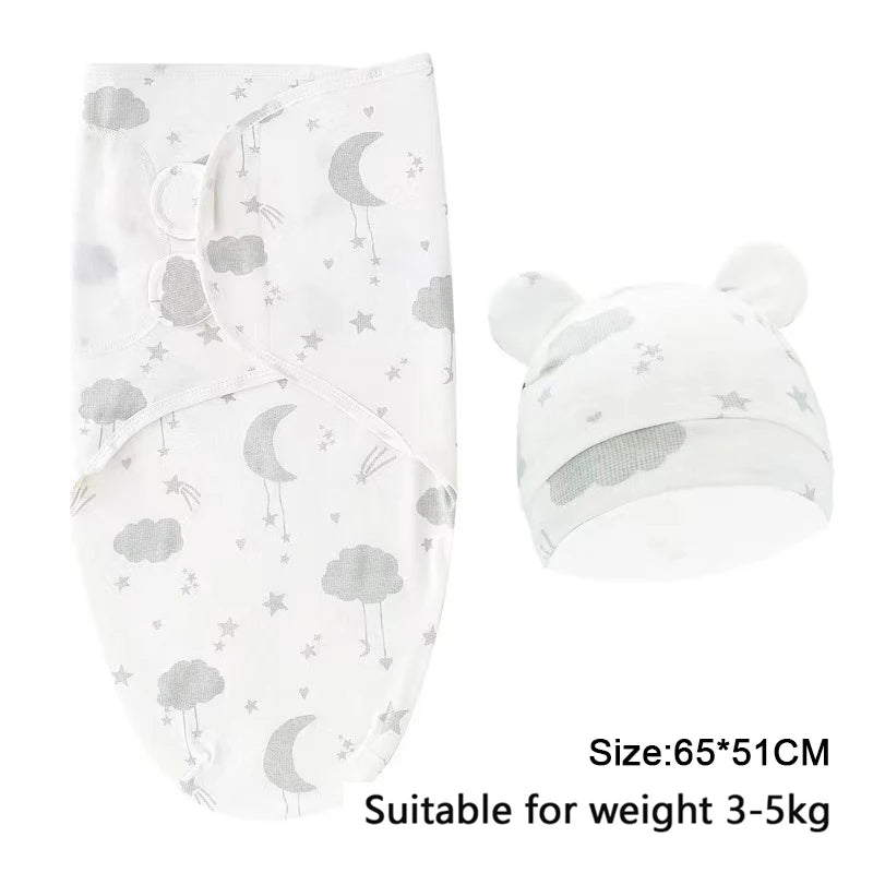 White cotton newborn swaddle blanket and hat set with a moon and cloud pattern