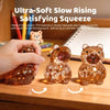 A close-up of an orange glitter capybara squishy toy being squeezed by a hand on a wooden surface.