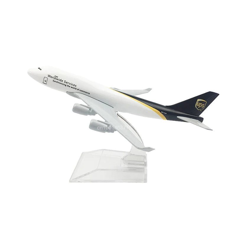 A white diecast model of a Boeing airplane with UPS branding on the tail, displayed on a clear stand.