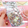 A hand is holding an open 21-piece miniature cottage 3D sticker book filled with small decorative stickers for journaling and