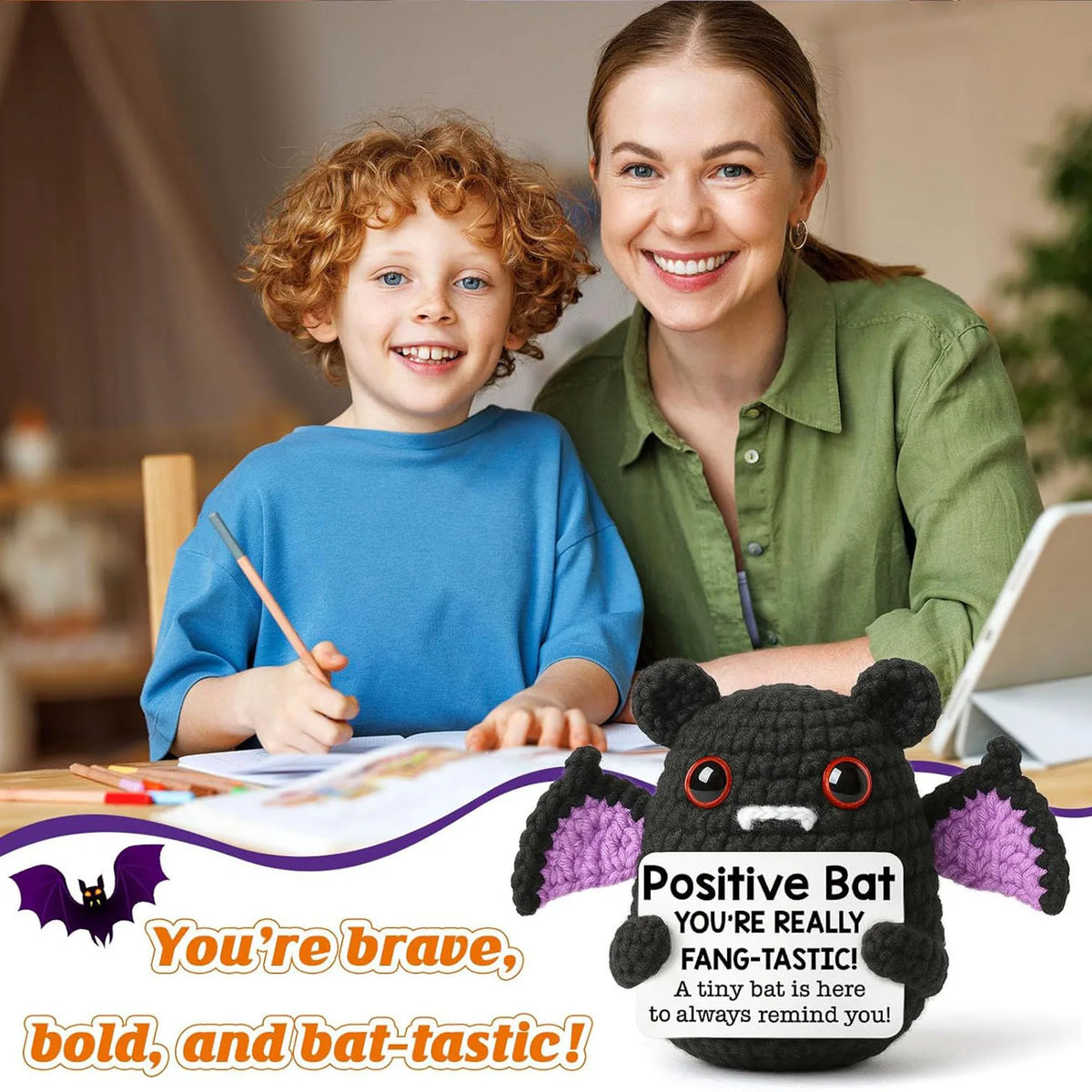 A smiling woman and a child holding a knitted black bat doll with a gift card tag.