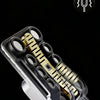 A close-up view of a metal magnetic fidget slider with gold and black components.