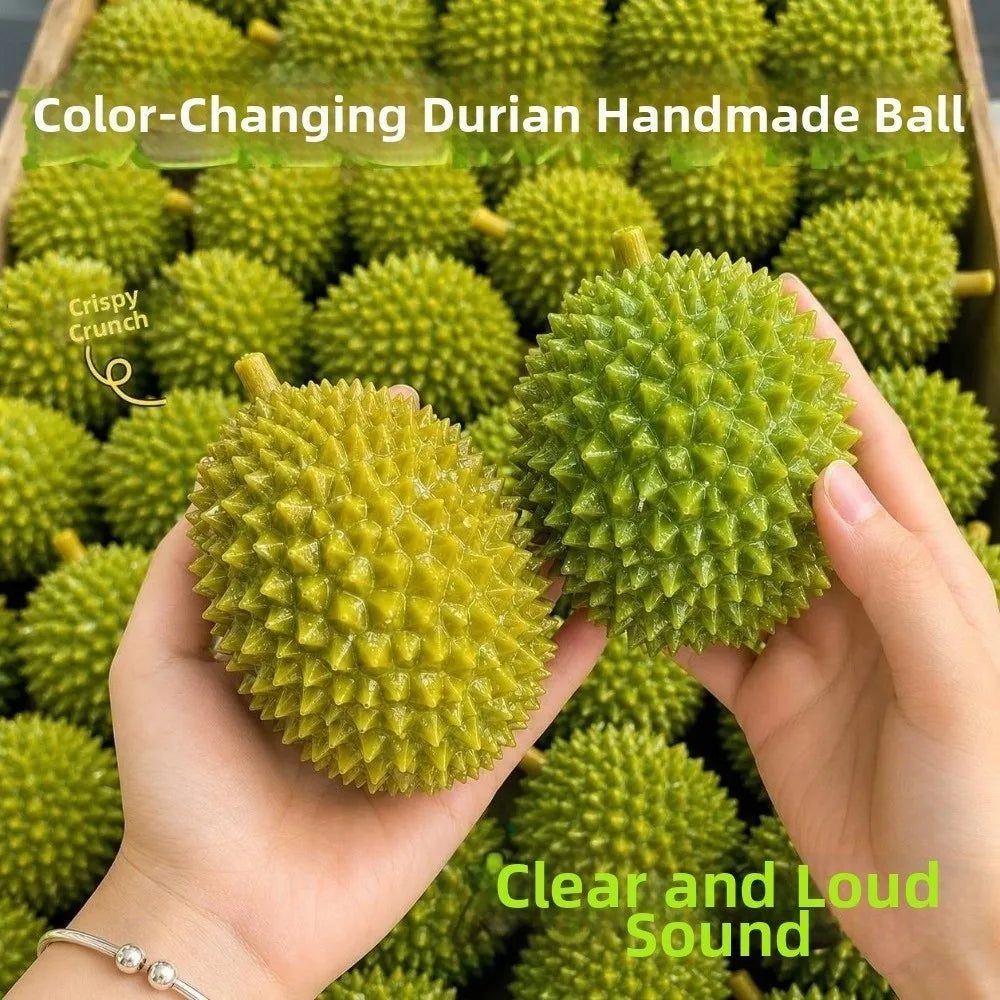 A hand holds a green durian handmade ball with a spiky texture, demonstrating its clear and loud sound.
